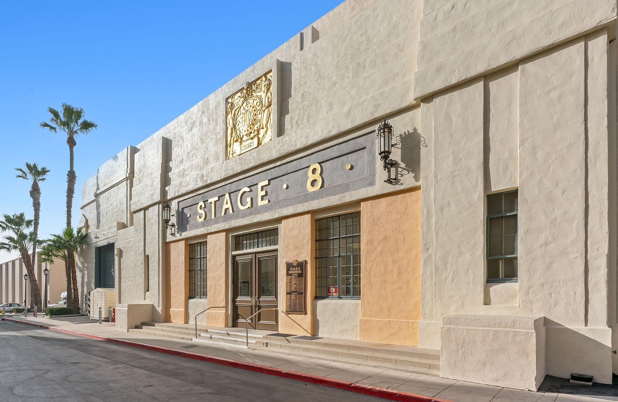 Studio building labeled 'STAGE 8' with a golden crest and palm trees.