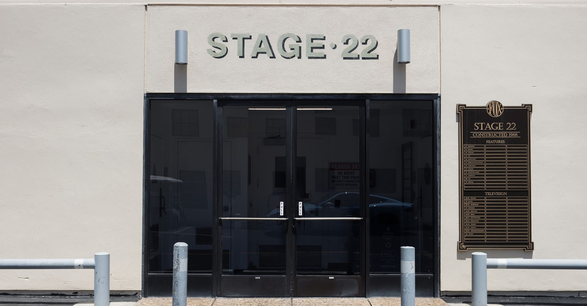 Exterior of Studio Stage 22 with glass doors and a plaque listing its productions.