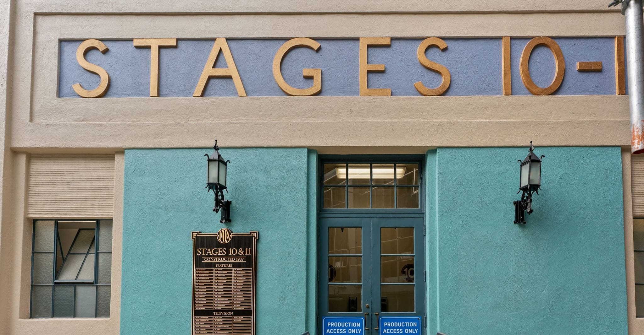 Building entrance with "STAGES 10-11" in gold letters above a teal facade.
