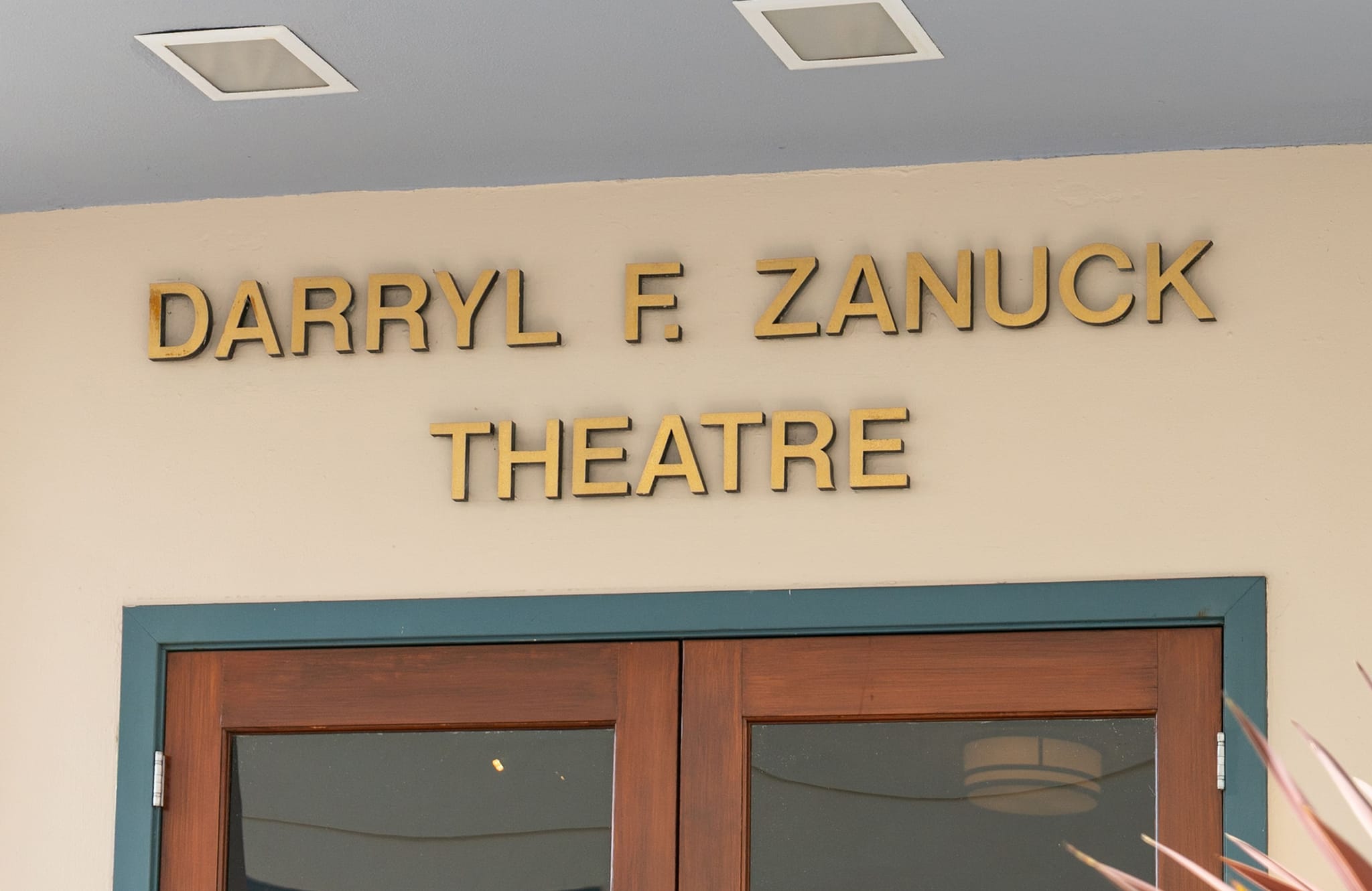 Gold letters spell "Darryl F. Zanuck Theatre" above double wooden doors.