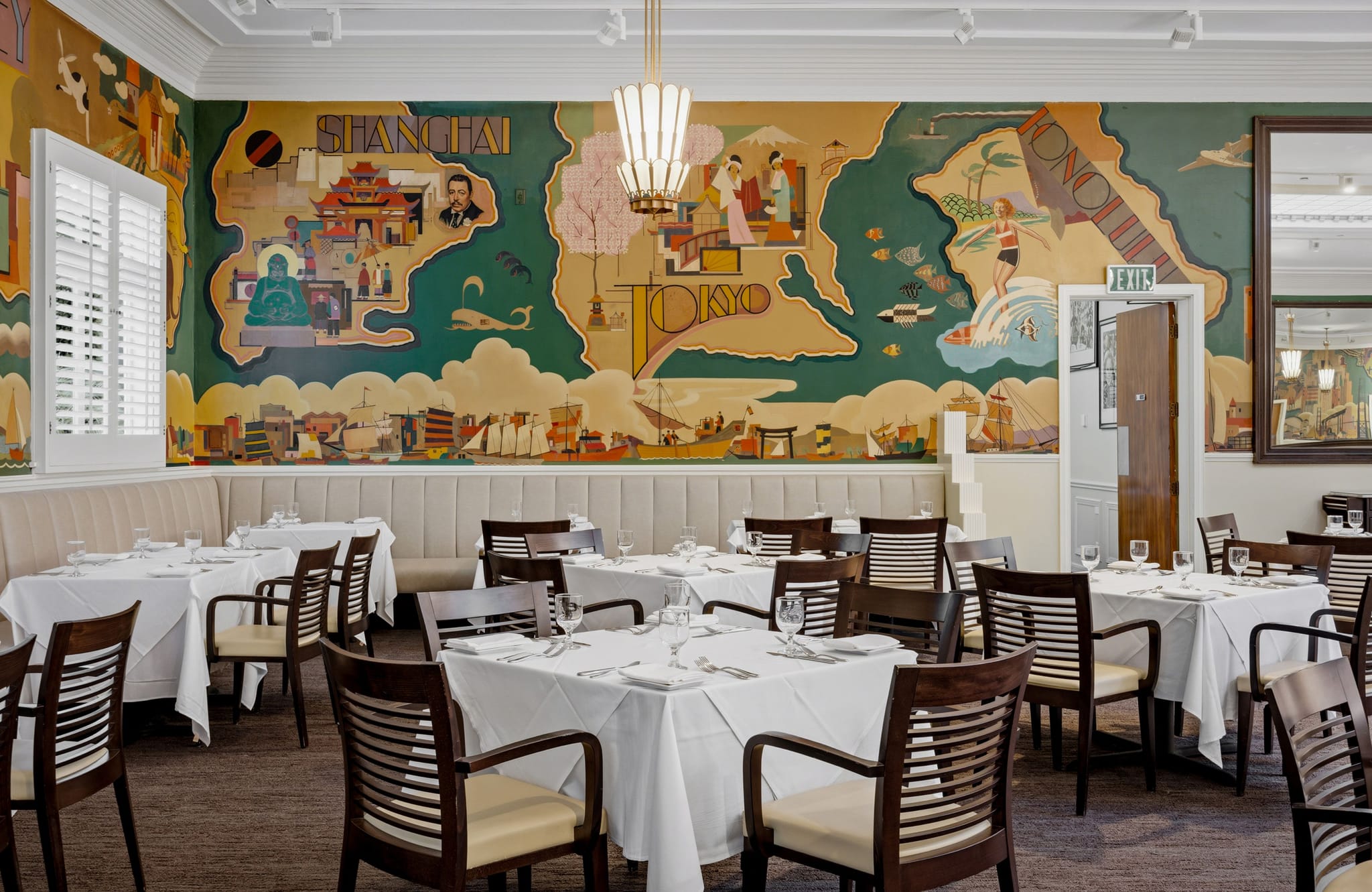 Restaurant dining room with white-linened tables and a vibrant mural depicting Shanghai, Tokyo, and Honolulu.