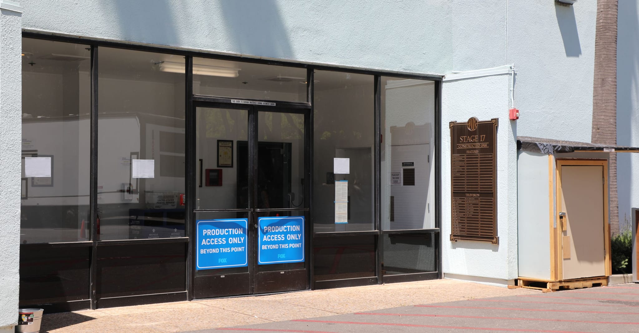 Glass entrance to Stage 17 Commissary Bldg with "Production Access Only" signs on the doors.