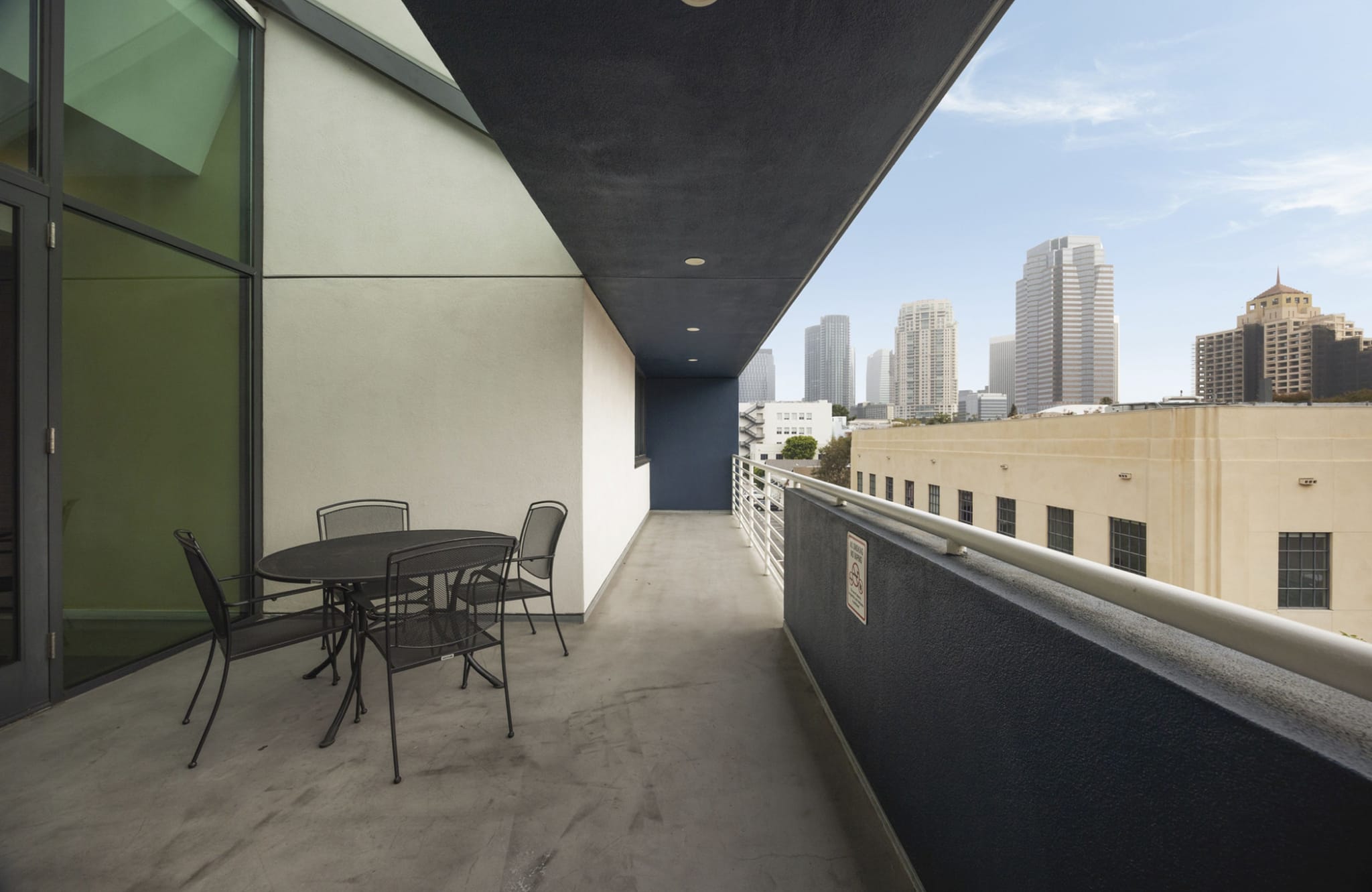 Balcony with patio furniture and a city skyline view.