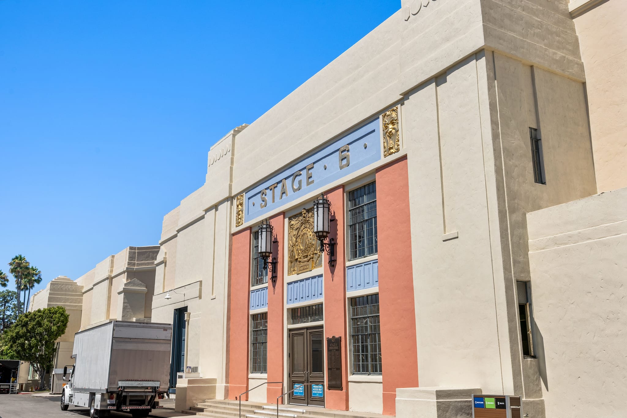 Art Deco building labeled "STAGE 6" with a white truck parked in front.